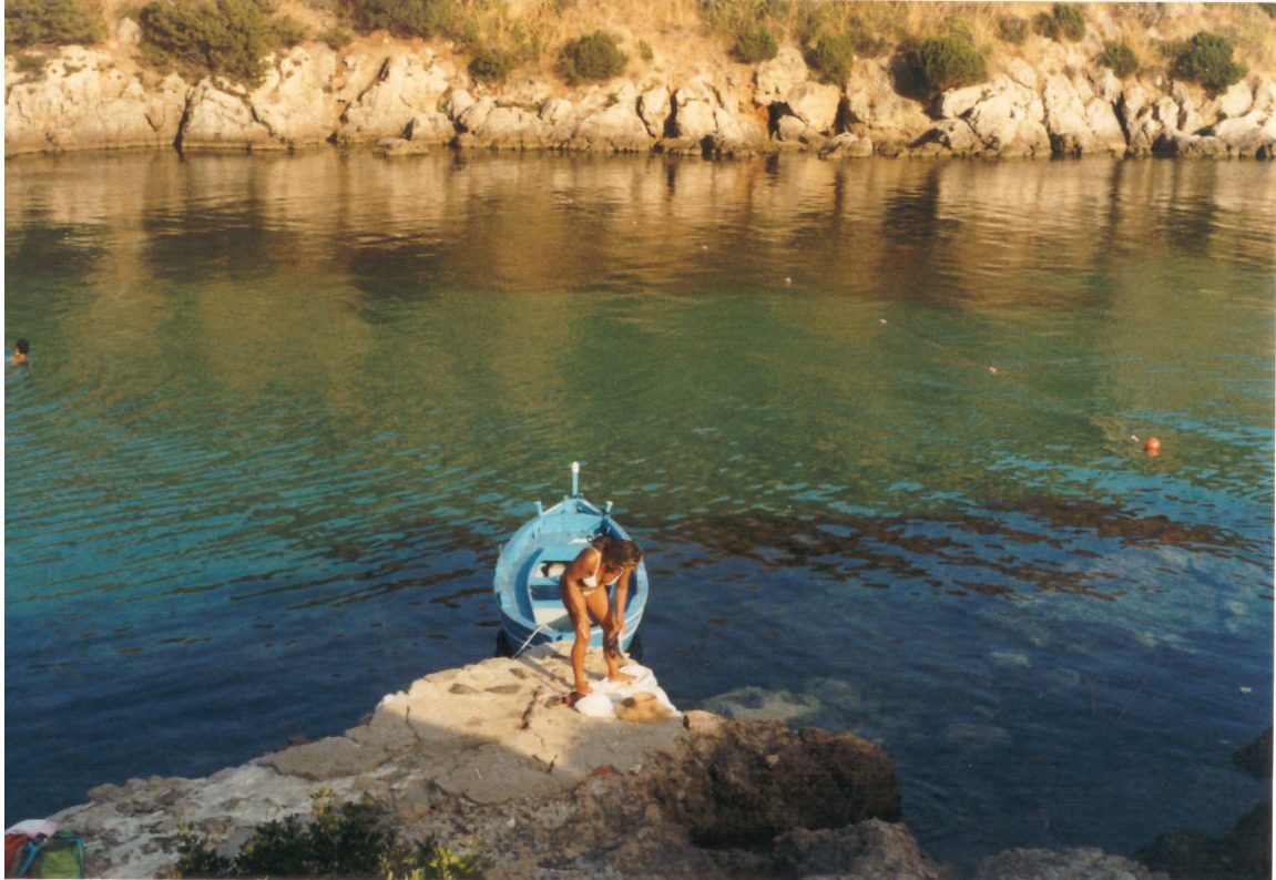 Una persona sugli scogli in riva all'acqua